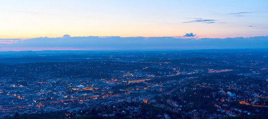 Night falls over Stuttgart City in Germany / Turning on the lights in the city