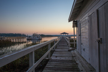 Sunrise over the marsh with a wooden dock and water