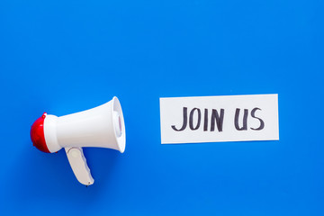 Membership concept. Hand lettering Join us near megaphone on blue background top view copy space