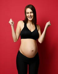 Young pregnant happy mother woman happy smiling on red