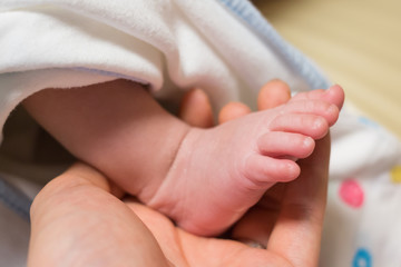 new born baby foot on father's hand