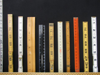 Folding rulers and scales in metric and inches form a bar chart and represent concepts of accuracy,...