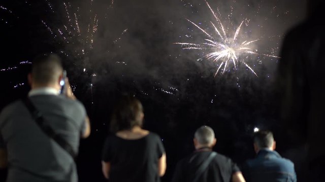 People looking fireworks. Group of people watching fireworks at night sky