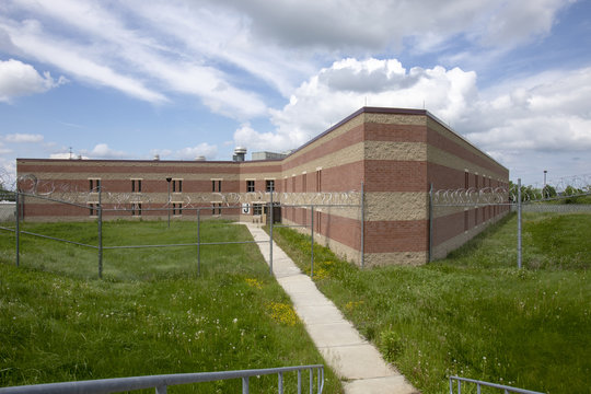Exterior of prison cell block with overgrown yard