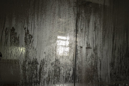 Condensation on mirror with reflection of light through window