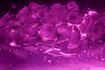 A pile of ice cubes in purple on a reflecting table