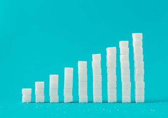 Financial chart made of sugar cubes with blue background. Sugar consumption growth rate world market concept.