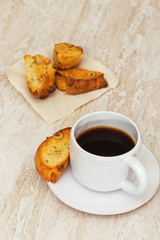 Italian dry homemade cookies cantucci on table and coffee in white cup. Simple food, home breakfast. Selective focus.