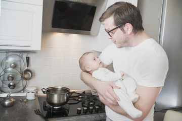 father with a infant newborn baby in the kitchen