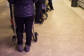 Fototapeta premium Close up of woman's legs and feet with luggage cart with bag