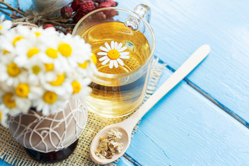 cup of herbal chamomile tea with fresh daisy flowers on wooden background. doctor treatment and prevention of immune concept, medicine - folk, alternative, complementary, traditional medicine 