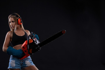 Tempting young woman posing with chainsaw