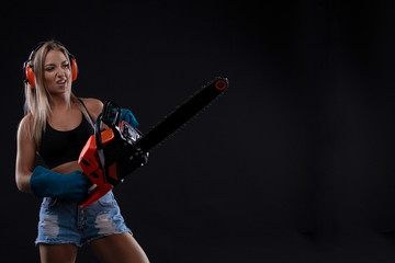 Tempting young woman posing with chainsaw