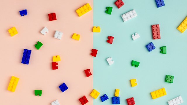 Plastic building blocks on blue and pink background