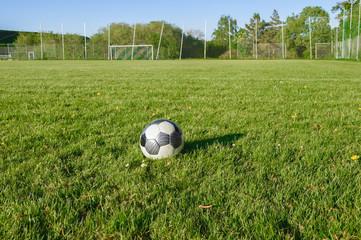 Im Sommer auf einem leeren Fußballplatz. Der Rasenplatz hat am Spielfeldrand keine Werbung angebracht. Ländliche Gegend im Sauerland.
