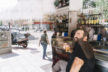 Bearded man who drinks beer in a bar in Madrid city