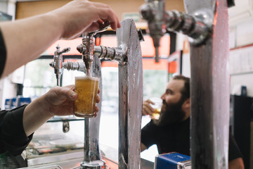 Bearded man who drinks beer in a bar in Madrid city