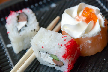 not eaten Japanese rolls in a container with Japanese sticks
