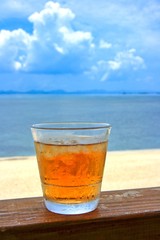 夏の海と爽やかなグラスの入ったお茶