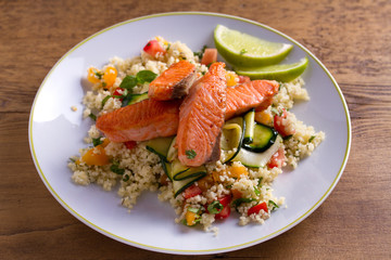Salmon with tomato couscous, zucchini and lime