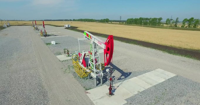 Aerial photography - Working oil pumps against sun / Oil pump jack. oil rocking oil field