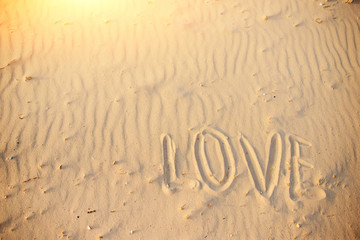 big text LOVE in the sand of the beach