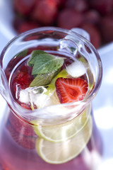 Strawberry lemonade drink, refreshing summer mojito with strawberries, lime and mint.