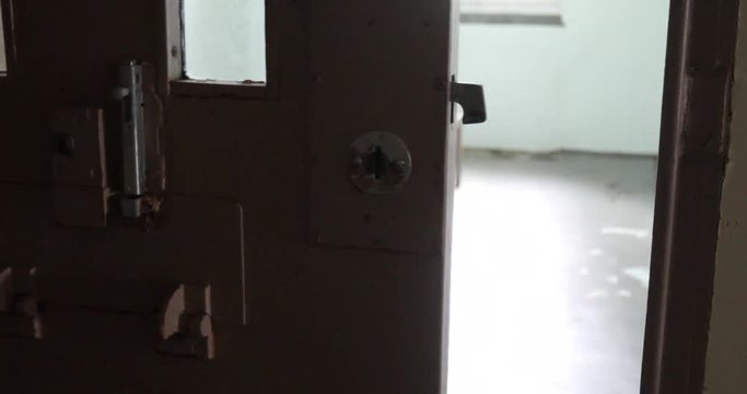 Door of solitary confinement cell opening in old prison.