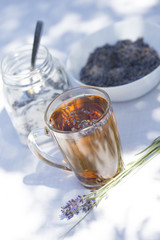 Herbal lavender tea in glass cup with lavender flowers