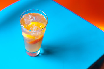 Orange juice on blue wooden background, top view. Closeup glass of cocktail