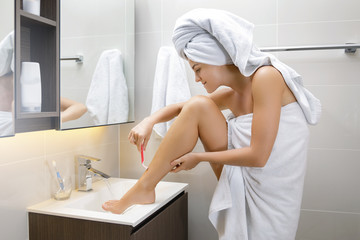 Woman is shaving her legs