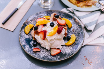Fresh baked Pancakes topping with strawberry, orange, blueberry and whip cream.  