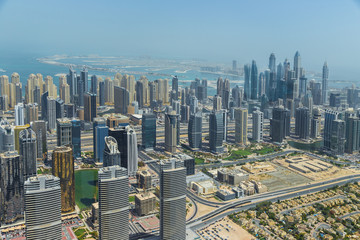 Aerial view of modern skyscrapers and sea in the background in Dubai, UAE.
