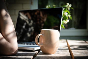 job with computer outdoors by wooden table at country, work from home concept, office desk in the yard, sunny day
