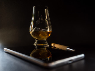 whisky glass with wood pen and smartphone from above