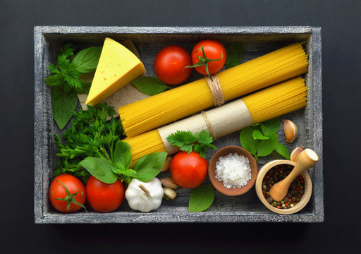 Food background, ingredients for cooking dinner. spaghetti, vegetables, sauces and spices,dark  background . copy space.  top view.