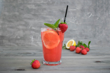 Fresh pink lemonade with lemon, lime and strawberries
