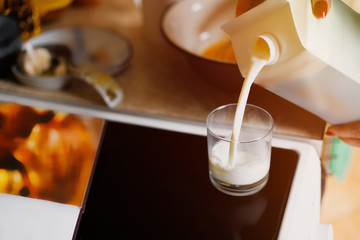 Mother pours milk into a glass.
