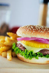 A served hamburger with a pineapple topping in the middle.  