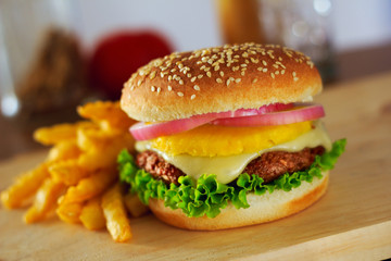 A served hamburger with a pineapple topping in the middle.  