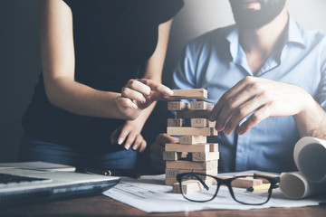 woman and man hands wooden cubes on table