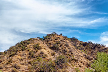 Warm summer clouds over desert mountain peak on warm morning