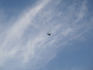 Small airplane flying in sky with clouds