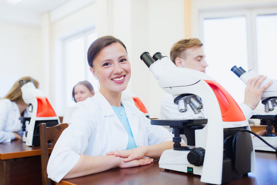 High school students using microscopes in laboratory