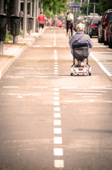 handicapped old woman using an electric wheel chair in the streets of Madrid