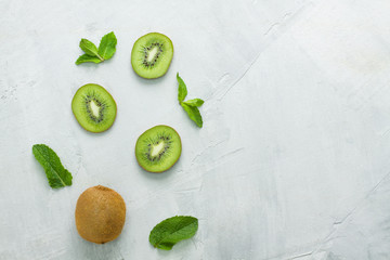 Fresh kiwi whole fruit slices mint on grey concrete background