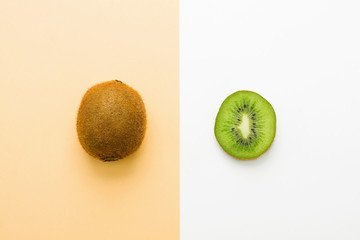 Obraz premium Fresh kiwi whole fruit and slice on orange white background