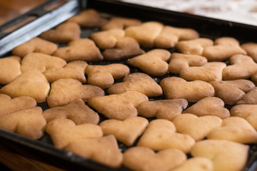 Ready festive shortbread biscuits in the shape of hearts for Christmas and Valentine's Day, lie on the baking sheet from the oven. 