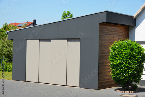 "Moderne Garage mit Automatik-Schiebetor in der Hauszufahrt" Stockfotos