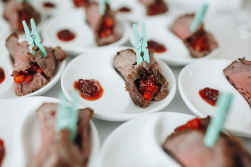 a sumptuous appetizer of ham rolls on white plates.